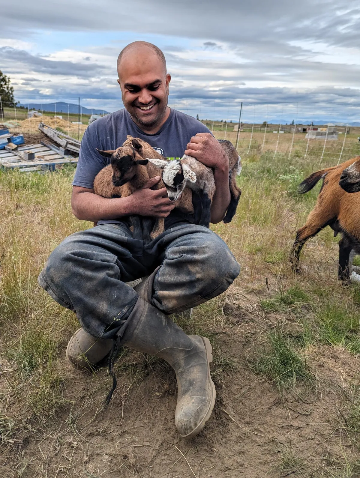 Himanshu Mehru holding goat kids on his farm in eastern Washington
